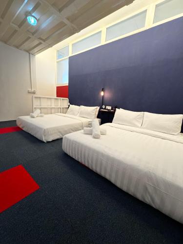 a room with two beds and a blue wall at The Harbour by Moonknight in George Town