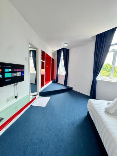 a hotel room with a bed and a flat screen tv at The Harbour by Moonknight in George Town