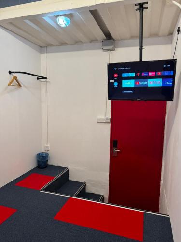 a room with a red door with a tv on the wall at The Harbour by Moonknight in George Town