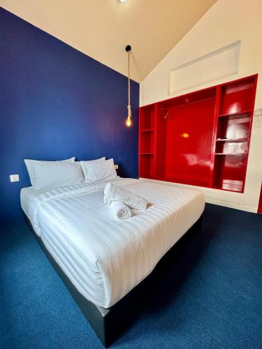 a bedroom with a large white bed with a red wall at The Harbour by Moonknight in George Town