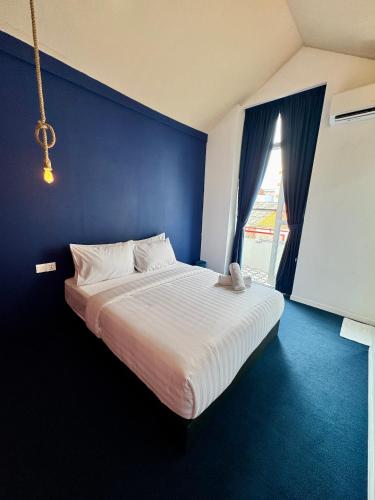 a bedroom with a large bed with a blue wall at The Harbour by Moonknight in George Town