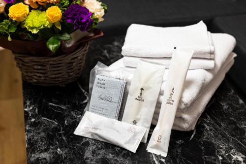 a table with towels and a basket of flowers at HITO 藤崎 Fujisaki in Fukuoka