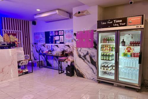 a store with purple walls and a cooler with drinks at Sabaidee Chiangmai Hotel in Chiang Mai
