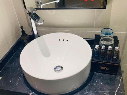 a white toilet in a bathroom with a sink at City Comfort Inn Hotel Wuhan Optics Valley Square Metro Station Zhongnan Minzu University in Wuhan