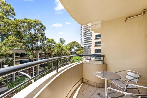 a balcony with a table and chairs on a building at Sleek 1-Bed by Jubilee Park with Pool in Sydney
