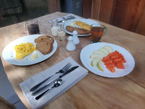 a table with two plates of breakfast food on it at Pondok Kebun Jati in Pawenang
