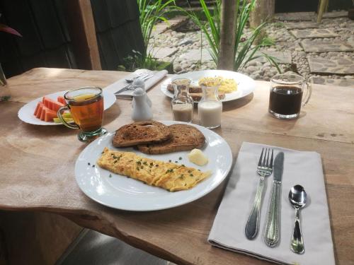 a table with a plate of food with bread and toast at Pondok Kebun Jati in Pawenang
