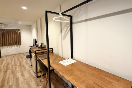 a room with a wooden table and a mirror at Sabaidee Chiangmai Hotel in Chiang Mai