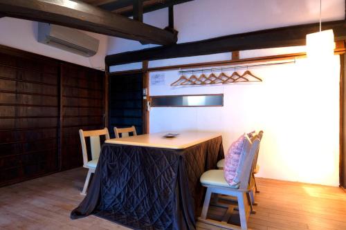 a table in a room with chairs and a table with at Kyoto HANATSUNAGI Hotel --- Kyoto city officially designated "KYO-MACHIYA" in Kyoto
