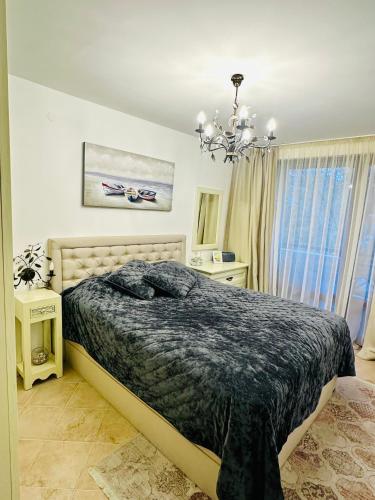 a bedroom with a bed and a chandelier at Seaside Oasis Apartment in Lozenets