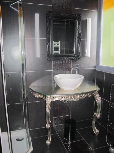a bathroom with a sink and a mirror at Hotel La Chaumiere in Dole