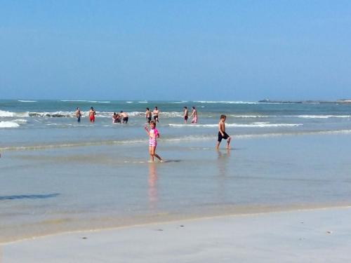 a group of people playing in the water at the beach at Mermaid Guest House in Struisbaai