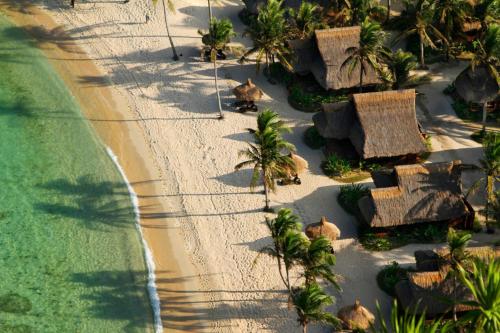 an aerial view of a beach with houses and palm trees at Cauayan Island Resort and Spa in El Nido