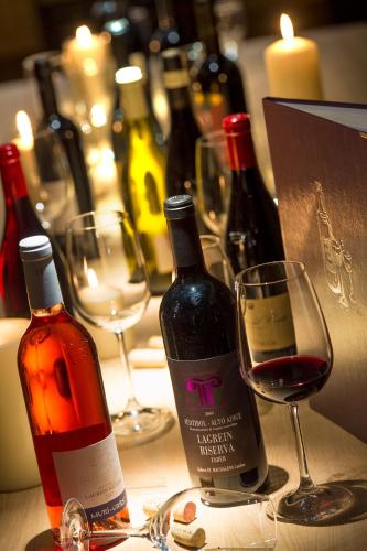 a table with two bottles of wine and a glass at Hotel Regglbergerhof in Nova Ponente
