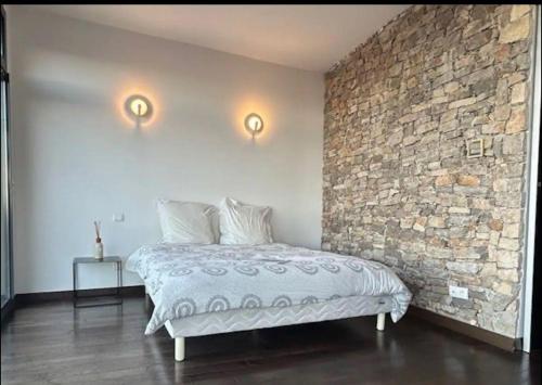 un lit dans une chambre avec un mur de briques dans l'établissement Superbe Villa sur le mont Saint Clair à Sete, à Sète