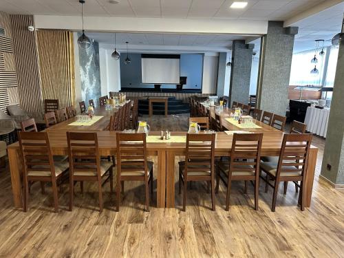 a conference room with a large wooden table and chairs at Hotel Alf in Borovany