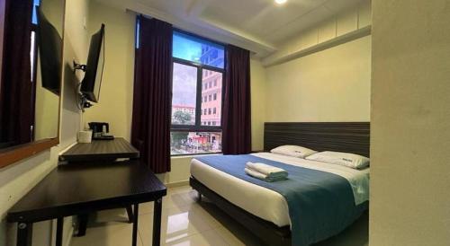 a bedroom with a bed and a desk and a window at Darlene Hotel in Singapore