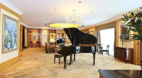 a piano in a room with a living room at Regency Hotel in Shantou
