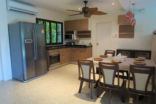 邦濤海灘的住宿－Tan ROCK RESORT，厨房配有桌椅和冰箱。
