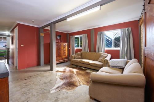 a living room with two couches and red walls at The Crab Pot Sunshine Coast in Maroochydore