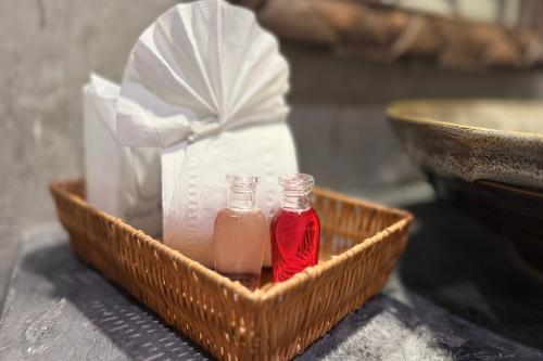a basket with two bottles of sauce and a bag at Sabaidee Chiangmai Hotel in Chiang Mai