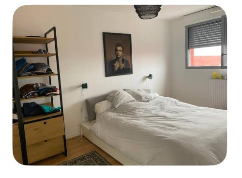 - une chambre avec un lit blanc et une étagère dans l'établissement Appartement sous les toits BX Bastide, à Bordeaux