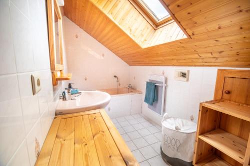 une salle de bain avec un lavabo blanc et une lucarne dans l'établissement Chalet Ô Gustav, vue montagne, au calme, 8p, à Xonrupt-Longemer
