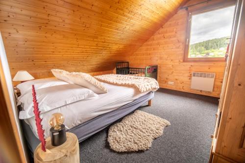 une chambre avec un lit dans une cabane en bois dans l'établissement Chalet Ô Gustav, vue montagne, au calme, 8p, à Xonrupt-Longemer