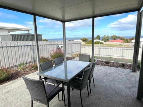 a dining table and chairs on a patio at Seaview on Terry Court in Kingscote