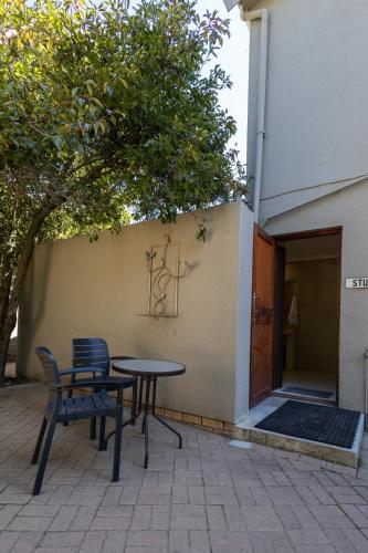 a table and chairs sitting next to a building at Bed On Boucher in Durbanville