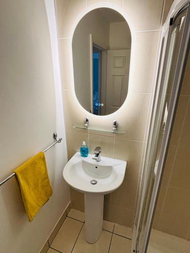 a bathroom with a sink and a mirror at Boru Walk Townhouse -Stylish & Modern Holiday Home in Killaloe