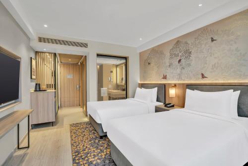 une chambre d'hôtel avec deux lits et une télévision à écran plat dans l'établissement Hilton Garden Inn Jabalpur, à Jabalpur