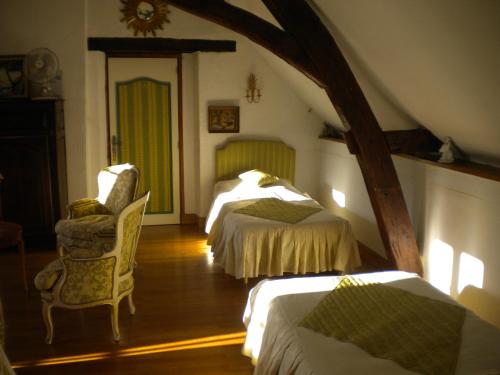 Een bed of bedden in een kamer bij Le Moulin Garnier