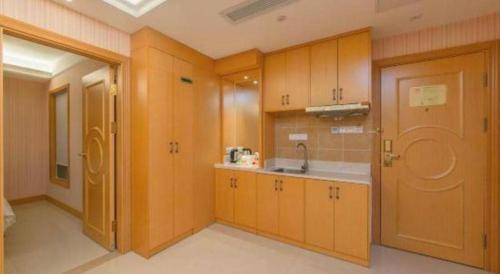 une cuisine avec des armoires en bois et un évier dans l'établissement Vienna Classic Hotel Guangdong Yangxi Moon Bay, à Dabang