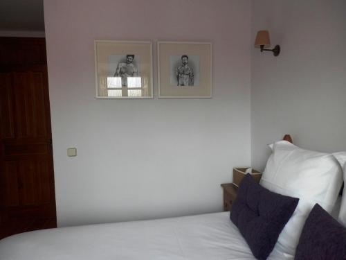 a bedroom with a bed with two pictures on the wall at La Casona de Castilnovo - Gay Men Only in Valdesaz