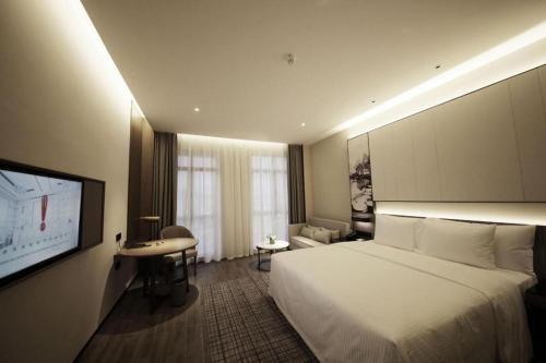 a hotel room with a bed and a flat screen tv at Wanda JIN Baise in Baise