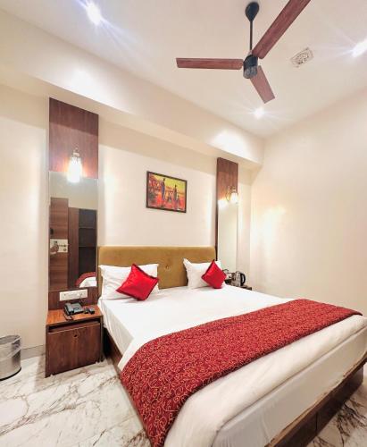 a bedroom with a large bed with red pillows at Hotel The Ceremony in Kalyan