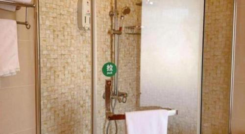 a bathroom with a shower with a sign on it at GreenTree Inn Shanghai Fengxian District Xiaotang Metro Station in Shanghai