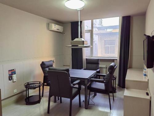 a dining room with a table and chairs and a window at Zhangye Pinmu Hotel(Yuncheng Zhongyin Avenue Store) in Yuncheng