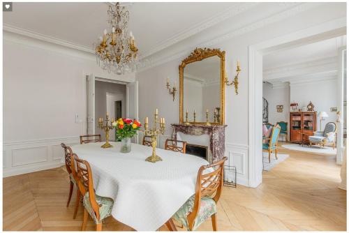 une salle à manger avec une table et un miroir dans l'établissement RUE Saint DIDier Champs Élysées, à Paris