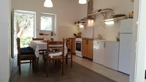 a kitchen with a table and a table and chairs at Holiday Home Shangri-La in Milna