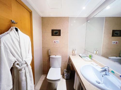 a bathroom with a sink and a toilet and a mirror at Holiday Inn Temple Of Heaven Beijing by IHG in Beijing