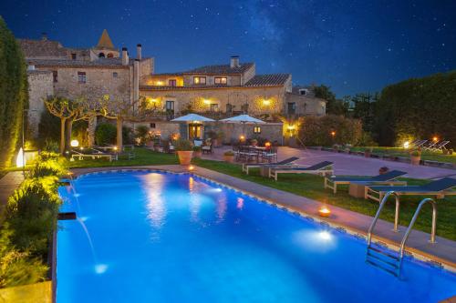 a large pool in front of a building at night at El Racó de Madremanya - Adults only in Madremanya