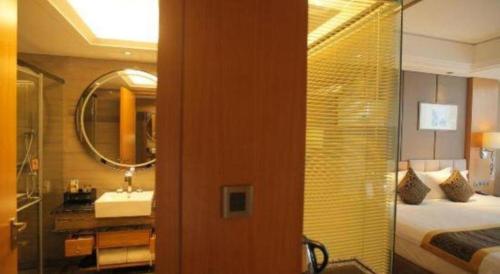 a bathroom with a bed and a sink and a mirror at Zhangjiagang Zhonglian GDH International Hotel in Zhangjiagang