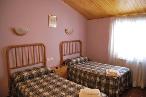 Habitación de hotel con 2 camas y ventana en Casa Puerto en Noguera de Albarracin