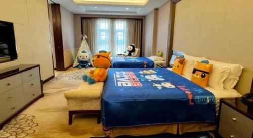a bedroom with a large blue bed with a stuffed animal on it at Linyi Blue Horizon International Hotel Yi He in Linyi
