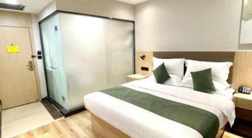 a bedroom with a large bed and a sliding door at GreenTree Inn Xinjiang Uygur Autonomous Region Korla Bazhou Bus Terminal Beishan Road Express Hotel in Korla
