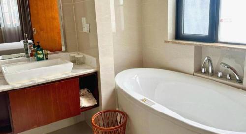 a bathroom with a white tub and a sink at Jinjiang Metropolo Shanghai Minhang in Shanghai