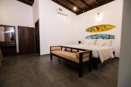 a bedroom with a bed with a surfboard on the wall at NatureSurf Villas - Private Garden Retreat at Hiriketiya Beach Yoga, Surf & Relaxation in Dickwella