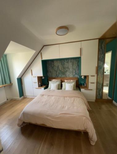 - une grande chambre avec un grand lit et des draps blancs dans l'établissement Villa Proche paris, à Servon